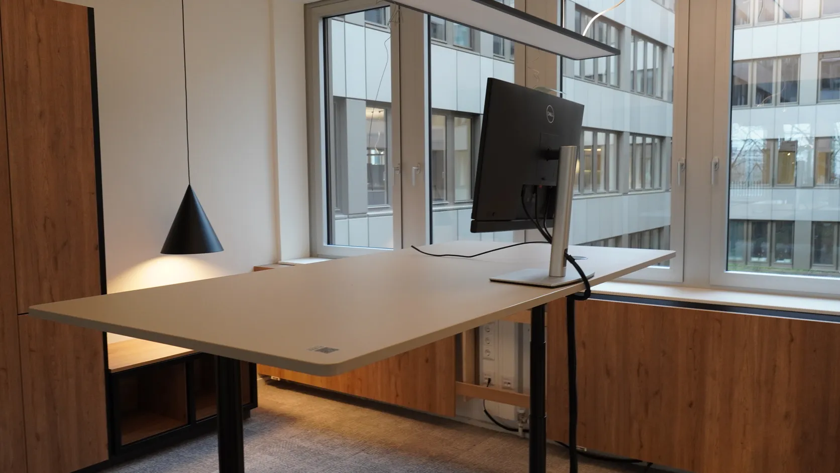 Frisch aufgebauter Arbeitsplatz mit Monitor an einem höhenverstellbaren Tisch in einem Hamburger Büro